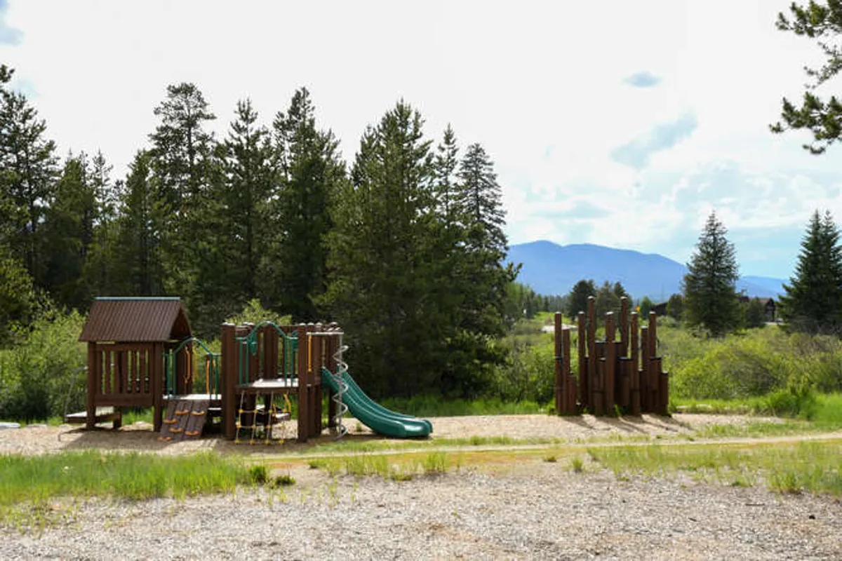 A colorful outdoor playground structure with slides and climbing features, set in a natural environment perfect for children and family gatherings.